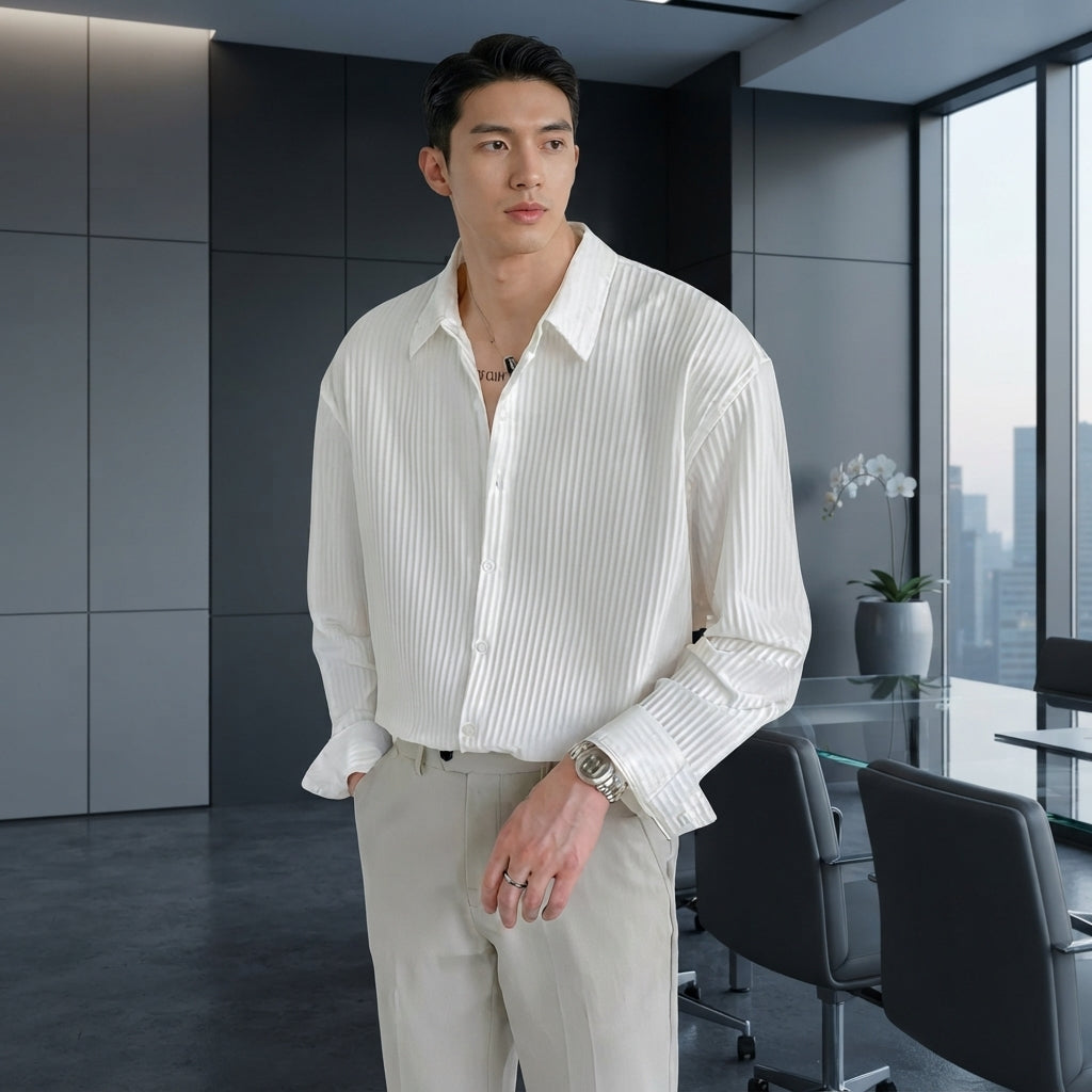 A professional man in a white textured slim-fit shirt standing in a modern office with charcoal and slate gray decor.