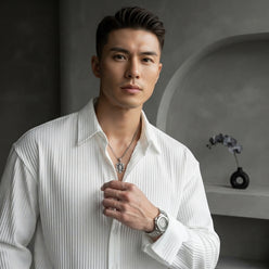 Alexander Sterling wearing a textured formal shirt in a minimalist studio setting with slate gray tones.