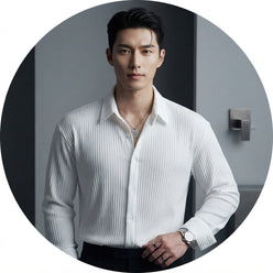 A professional portrait of Julian Brooks wearing a textured white popcorn fabric formal shirt against a minimalist gray backg